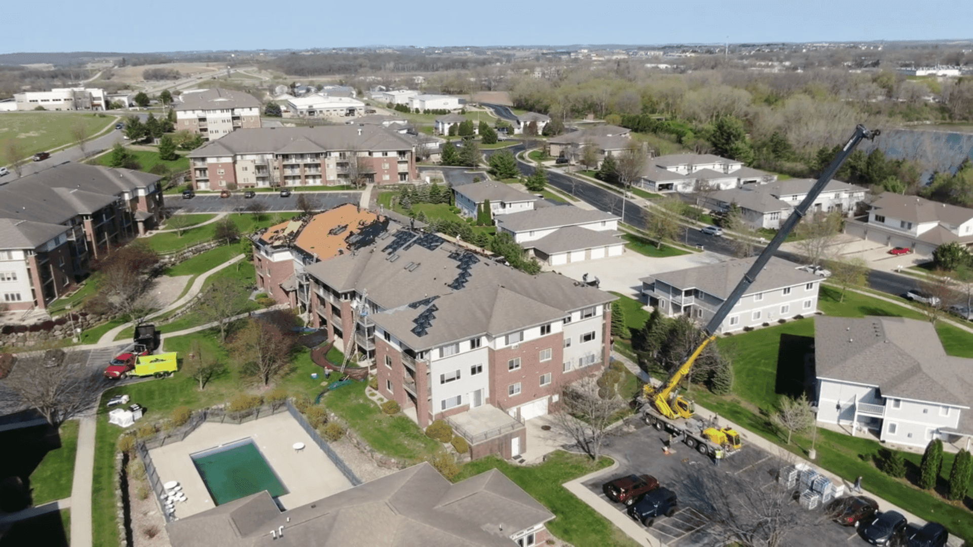 An aerial view of roofing being installed on a large building.