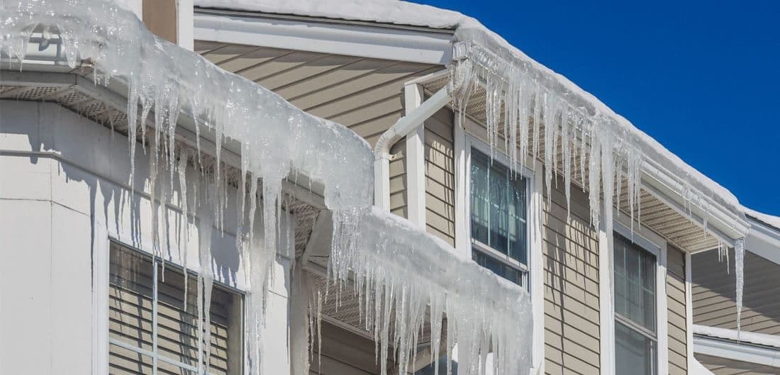 Large icicles hang from a roof.